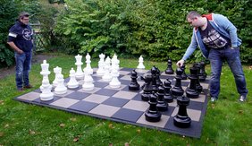 Alexander und Viktor spielen eine der ersten Partien auf dem neuen Gartenschachspiel mit 3,20m Kantenlänge